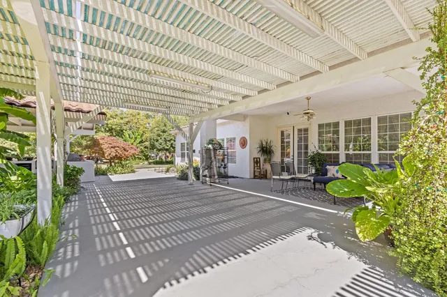 a front view of a house with a yard and potted plants