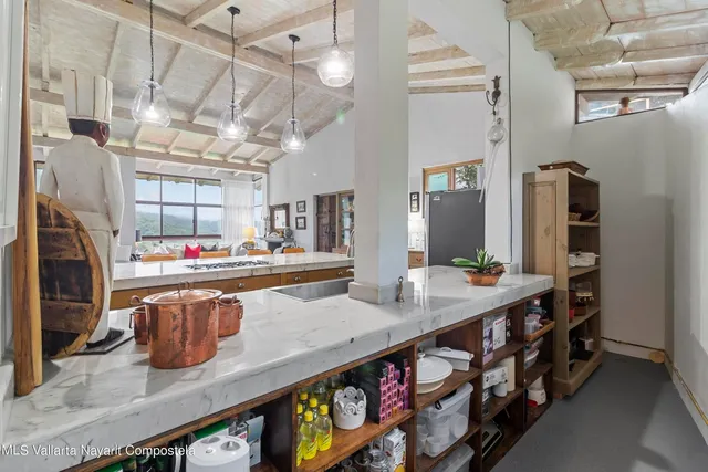 a kitchen with stainless steel appliances granite countertop a table chairs in it and wooden floors