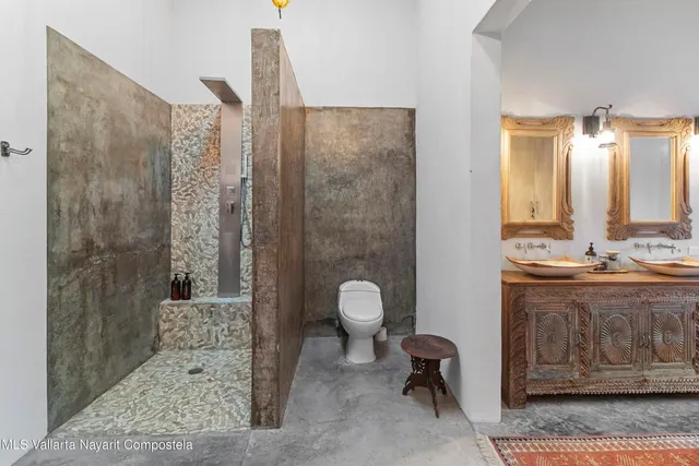 a bathroom with a granite countertop sink a toilet and shower