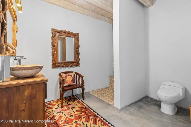 a bathroom with a toilet a sink and mirror