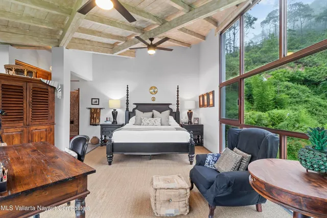 a bedroom with furniture and a large window