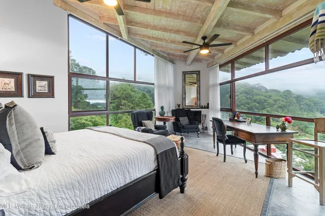 a bedroom with furniture a bed and a large window