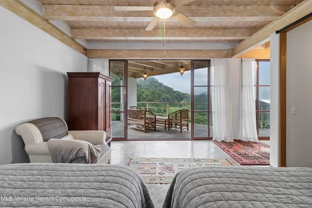 a bedroom with furniture and a large window