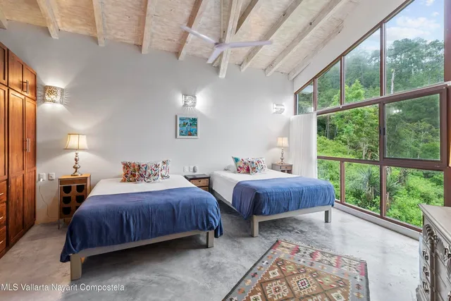 a bedroom with bed and a large window with outer view