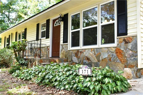 a front view of a house with a lot of flower plants