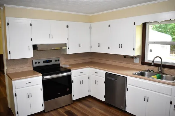 a kitchen with cabinets appliances and a sink
