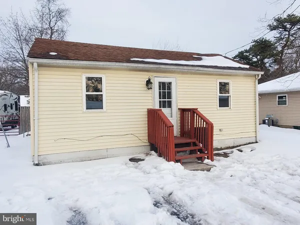 a view of a house with a yard and chairs