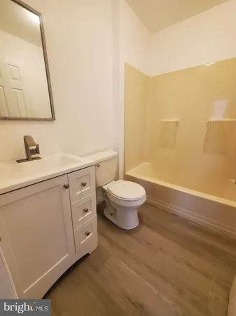 a bathroom with a granite countertop sink a toilet and a mirror