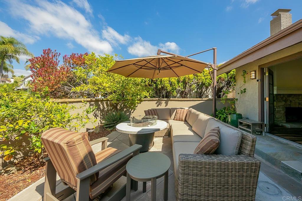 1641 Tucker Lane Encinitas, CA 92024 - Photo 4 of 58 a view of a patio with couches table and chairs under an umbrella