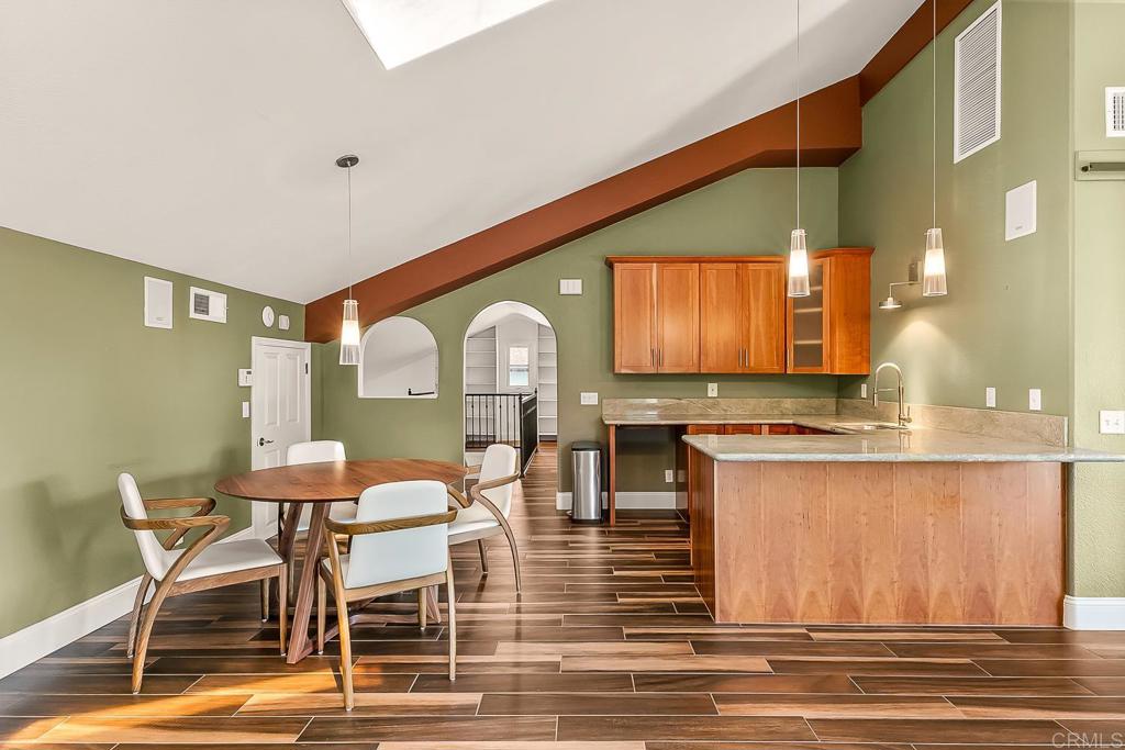 1641 Tucker Lane Encinitas, CA 92024 - Photo 49 of 58 a kitchen with stainless steel appliances kitchen island granite countertop a table chairs in it and wooden floors