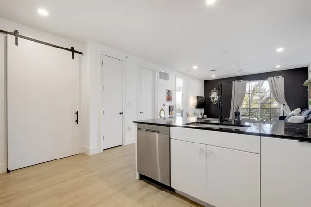 a kitchen with granite countertop a sink and a refrigerator