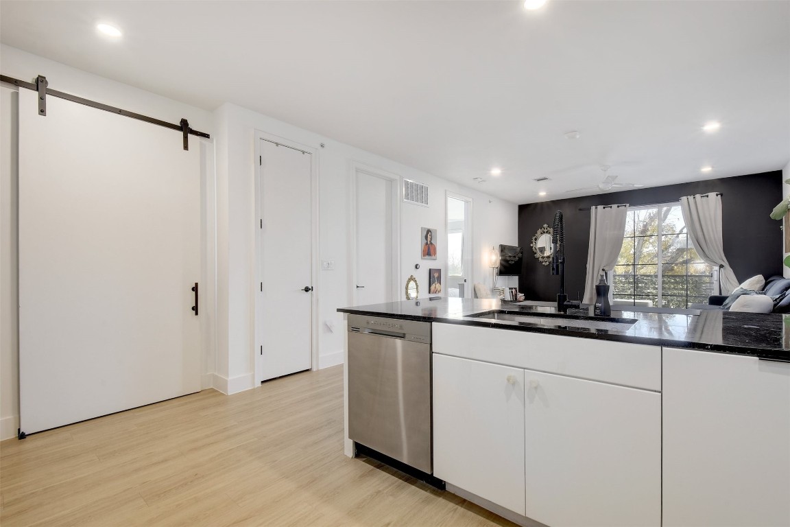 2709 East 5th Street, Unit 2303 Austin, TX 78702 - Photo 4 of 18 a kitchen with granite countertop a sink and a refrigerator