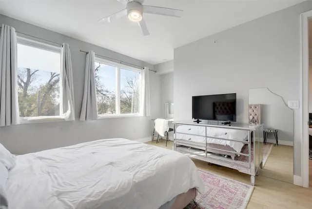 a bedroom with bed tv and window