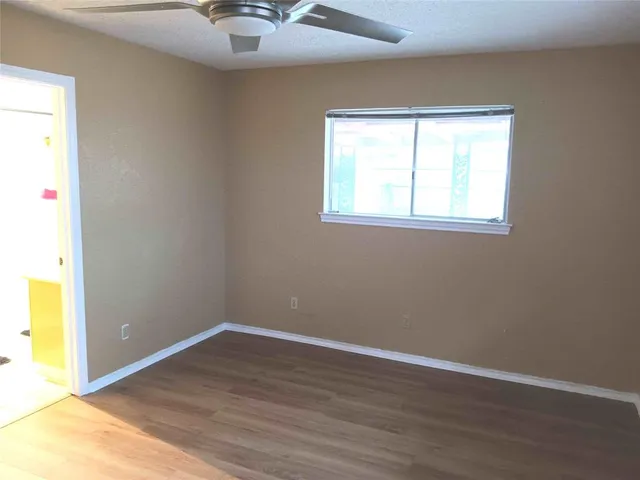 an empty room with a window and wooden floor
