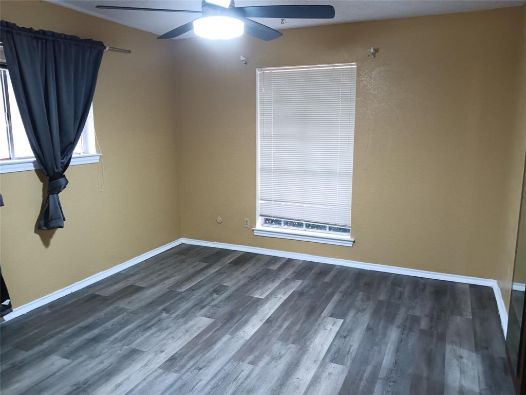 1113 Janell Drive Irving, TX 75062 - Photo 21 of 25 a view of an empty room with wooden floor and a window