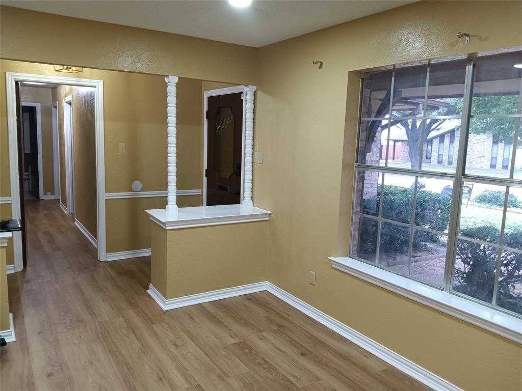 1113 Janell Drive Irving, TX 75062 - Photo 3 of 25 an empty room with wooden floor and a window