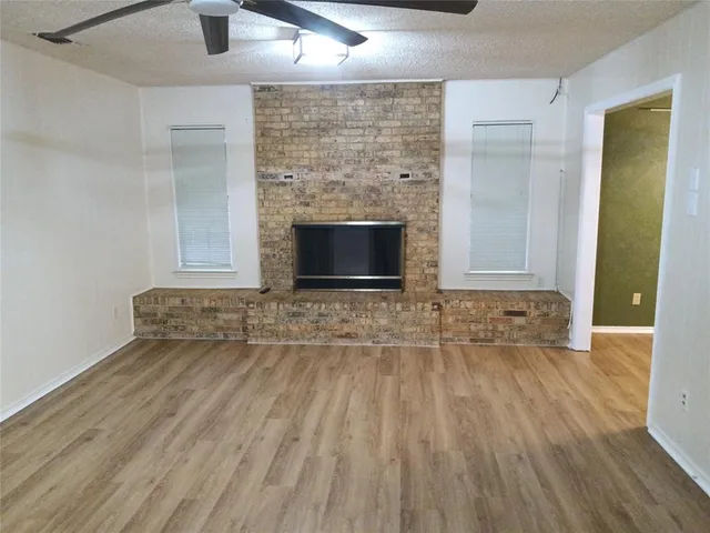 an empty room with wooden floor and fireplace