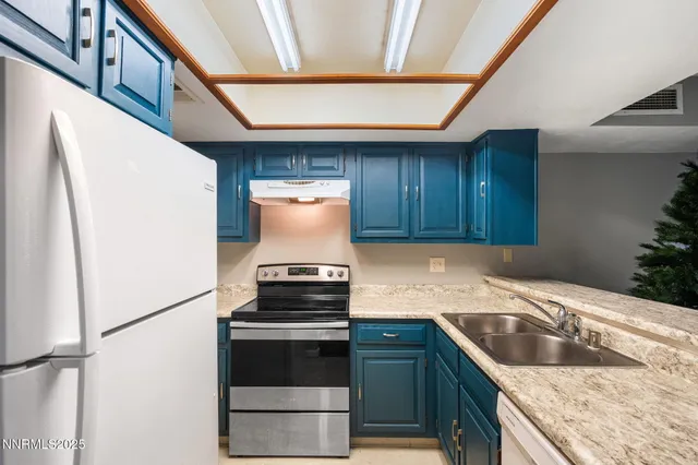 a kitchen with granite countertop a sink and a stove top oven