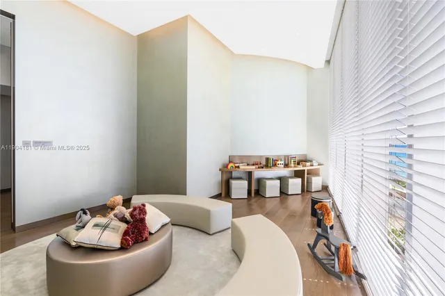 a living room with couches and kitchen view with wooden floor