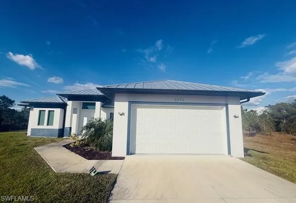 a front view of house with yard and trees