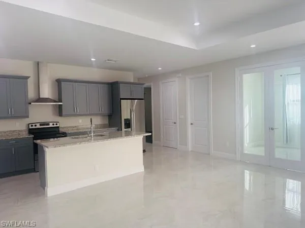 a kitchen with stainless steel appliances a refrigerator a stove a sink and white cabinets