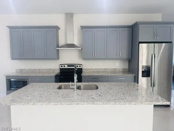 a kitchen with a refrigerator sink and cabinets