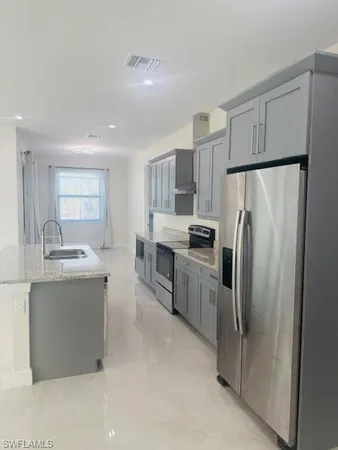 a view of kitchen with refrigerator and window