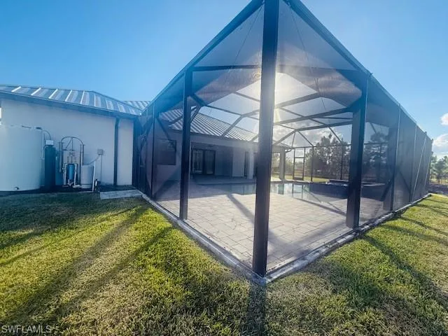 an empty room with wooden floor and windows with curtains