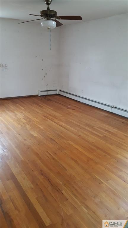 131 South Cliff Road Colonia, NJ 07067 - Photo 7 of 20 an empty room with a ceiling fan and wooden floor