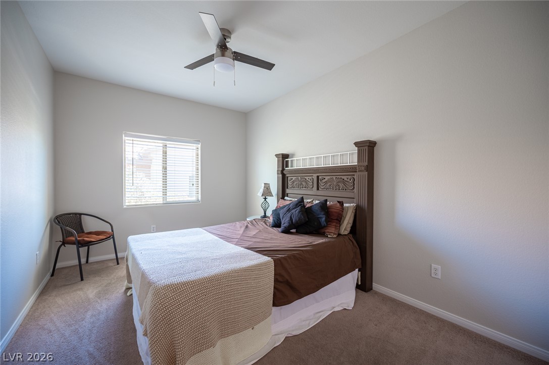 7701 West Robindale Road, Unit 274 Las Vegas, NV 89113 - Photo 25 of 43 A comfortable bedroom featuring a ceiling fan and carpeted flooring, perfect for peaceful rest.