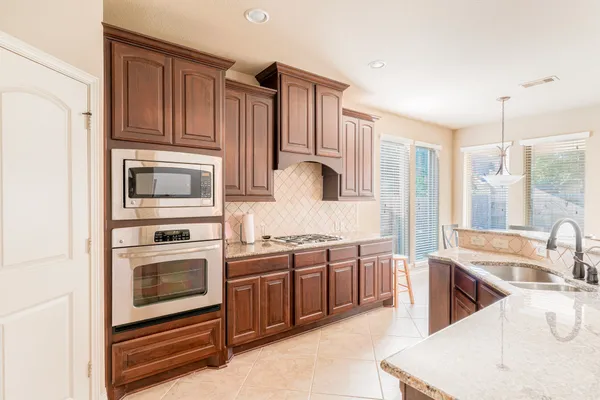 a kitchen with stainless steel appliances granite countertop a sink and dishwasher a stove with wooden floors