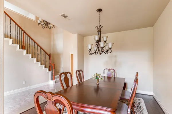a view of a dining room with furniture a chandelier and wooden floor