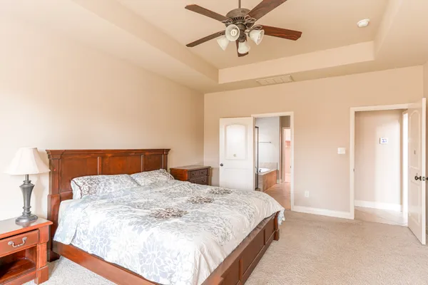 a bedroom with a large bed and a chandelier
