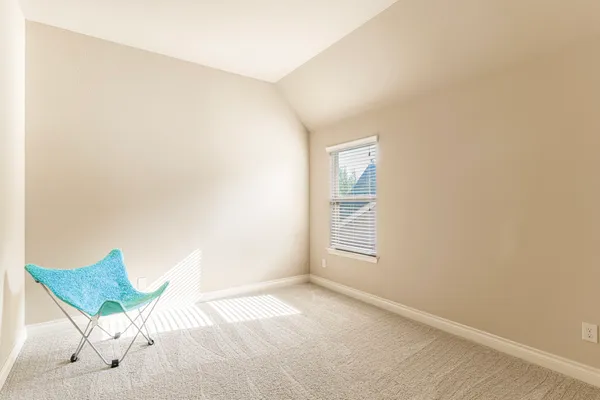 an empty room with a chair and potted plant