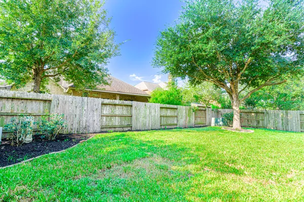 a view of a back yard with a small yard and wooden fence