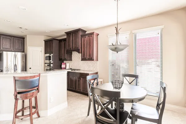 a kitchen with kitchen island a dining table chairs and a sink