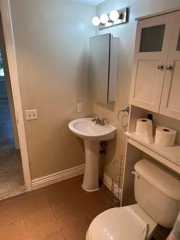 a bathroom with a toilet sink and mirror