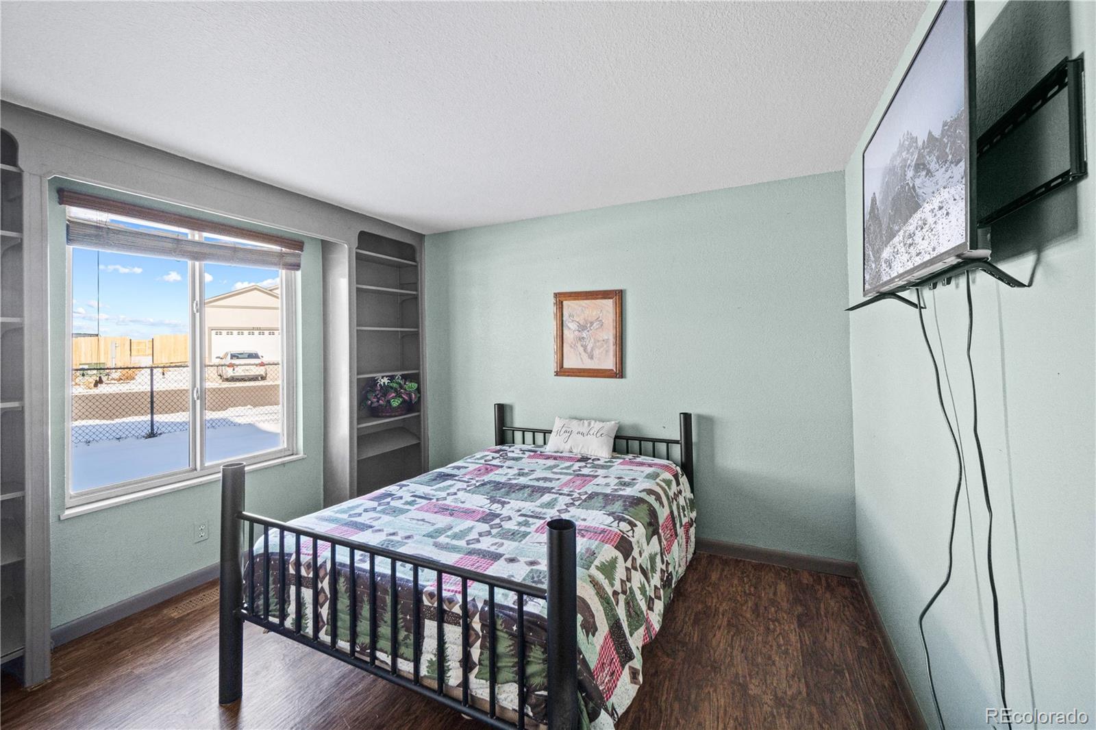 3126 County Rd CC254 Colorado City, CO 81019 - Photo 24 of 50 a bedroom with a bed a flat screen tv and a window