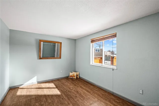a view of a room with wooden floor and a window