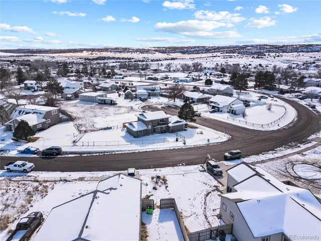 an aerial view of a house with a swimming pool and outdoor seating