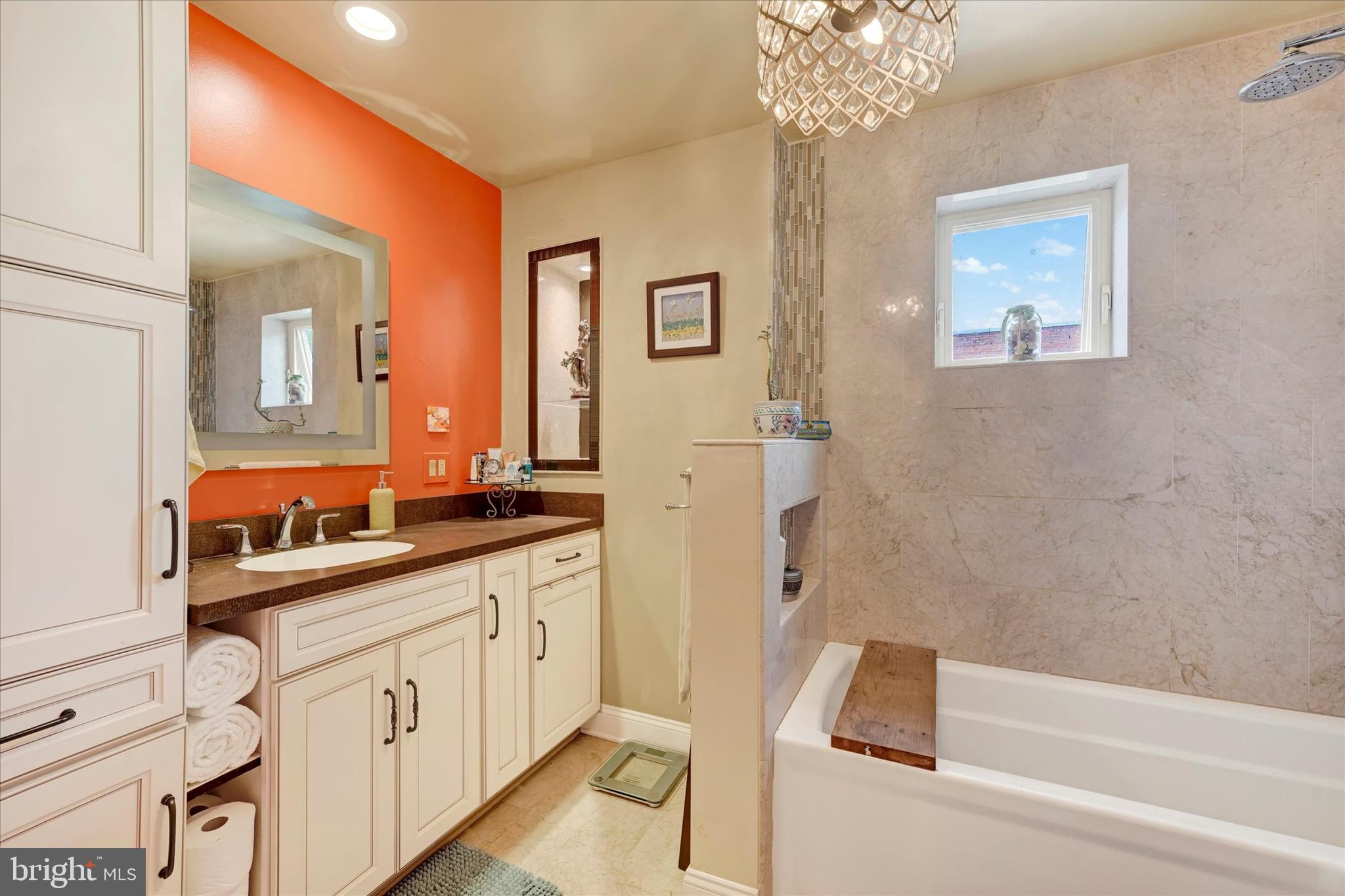 4224 Evans Chapel Road Baltimore, MD 21211 - Photo 14 of 24 a spacious bathroom with a double vanity sink a mirror and a bathtub