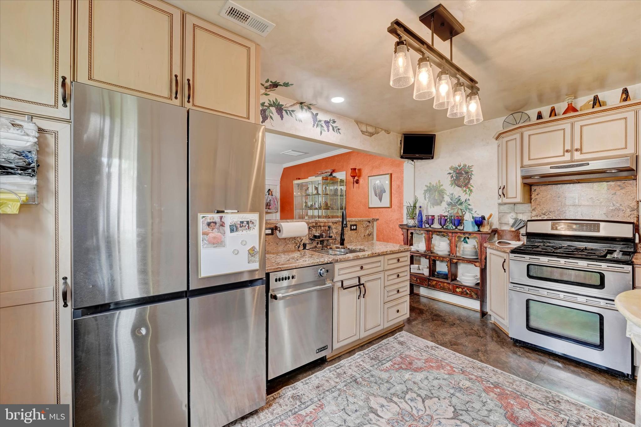 4224 Evans Chapel Road Baltimore, MD 21211 - Photo 8 of 24 a kitchen with stainless steel appliances a refrigerator sink and cabinets