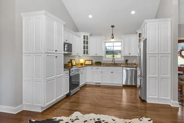 a kitchen with white cabinets and refrigerator