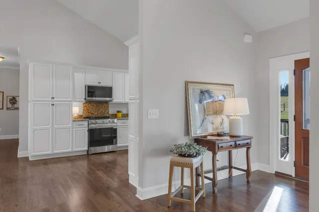 a living room with stainless steel appliances kitchen island granite countertop furniture and wooden floor