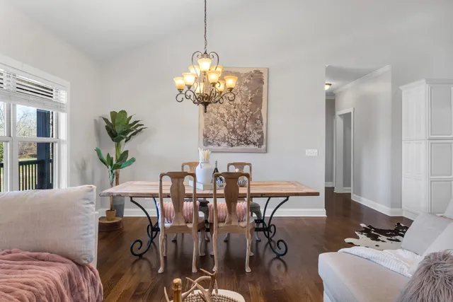 a view of a livingroom and dining room with furniture wooden floor and a chandelier