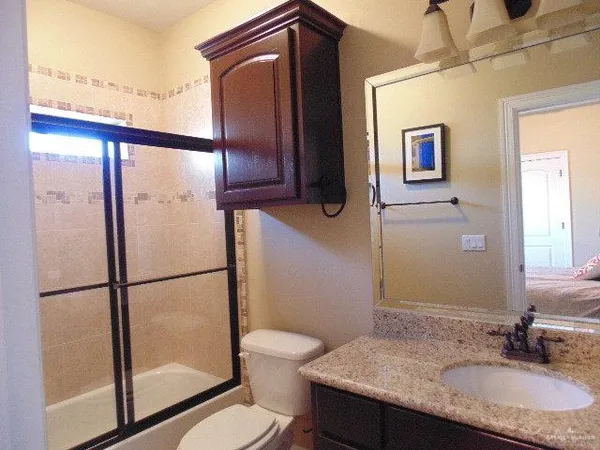 a bathroom with a granite countertop sink toilet and shower