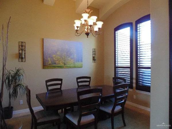 a view of a dining room with furniture and a chandelier