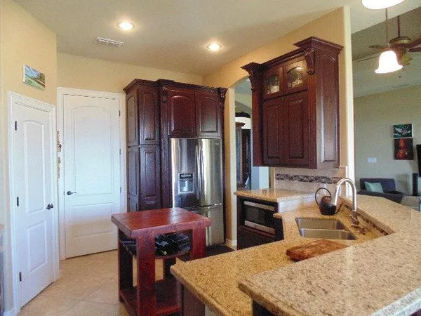 a kitchen with stainless steel appliances granite countertop a sink refrigerator and cabinets