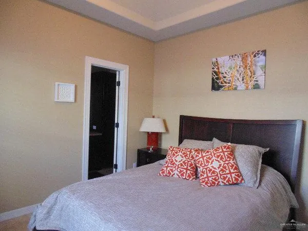 a bedroom with a bed and a lamp on dresser