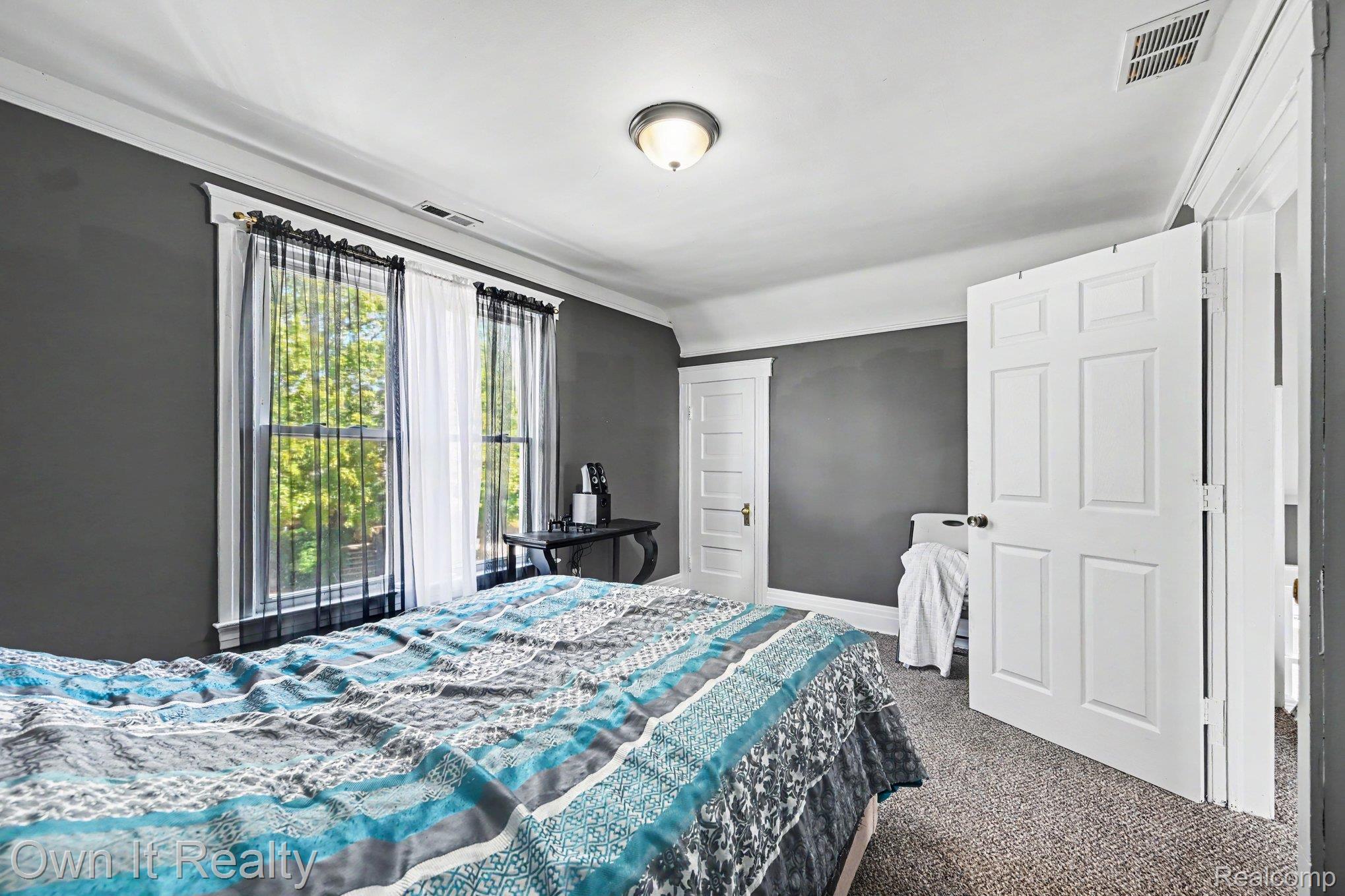 44 Maple Street River Rouge, MI 48218 - Photo 15 of 33 Neutral wall color, carpeted flooring, crown molding, double windows with trim, and a ceiling-mounted light fixture